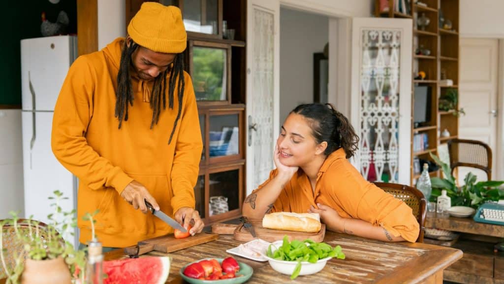 A couple preparing food in the kitchen together.