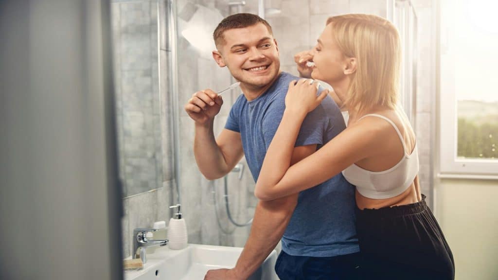 A couple brushing their teeth together