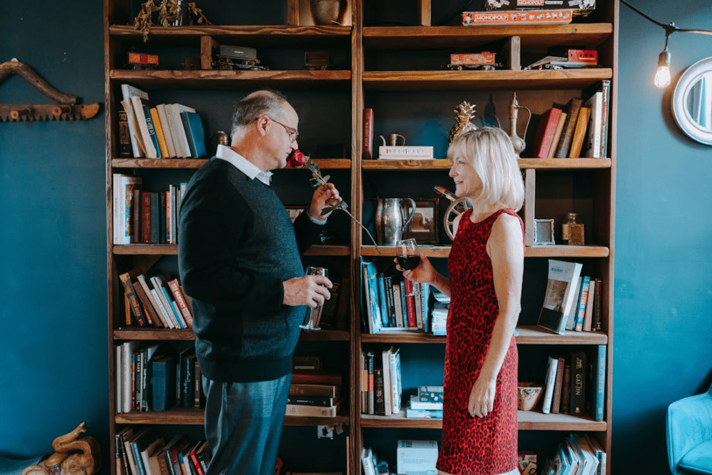 Photograph of a Man Smelling a Rose Near a Woman in a Red Dress
