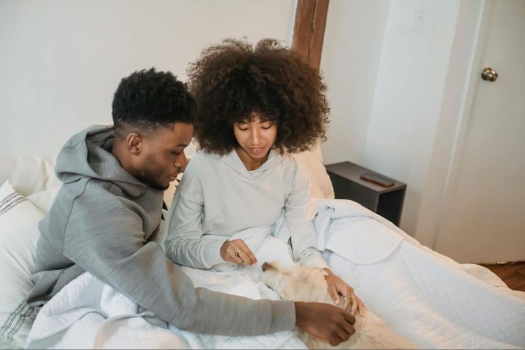A man and woman petting their dog