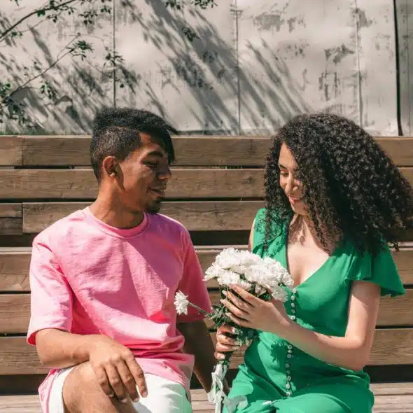 A man giving a flower to woman