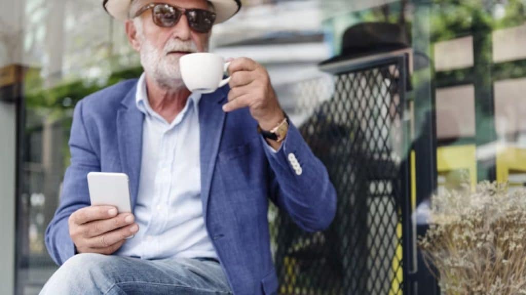 Man sitting with coffee, looking thoughtful but content