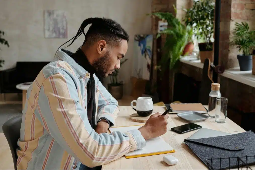 A man writing something to a notebook