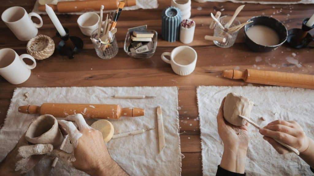 A pair of hands shaping clay during a pottery-making session.