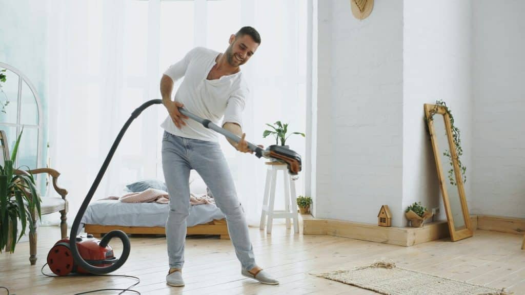 A man cleaning the living room