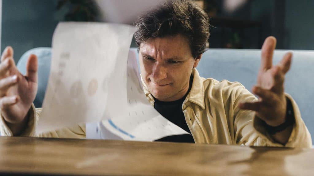 A frustrated man throwing papers into the air.