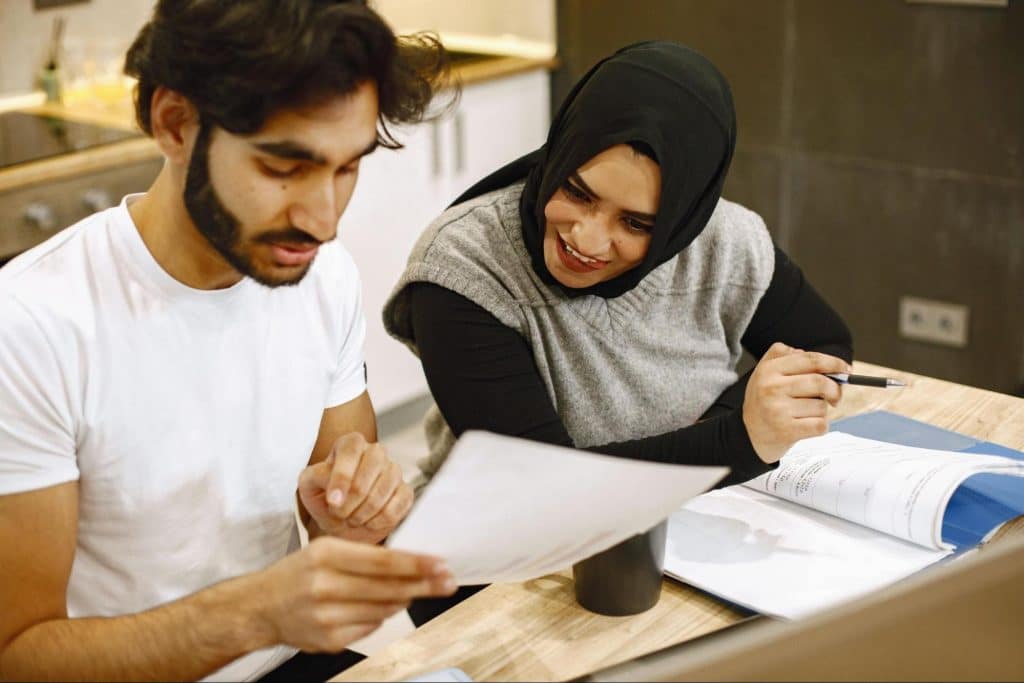 A woman checking on a man’s work 