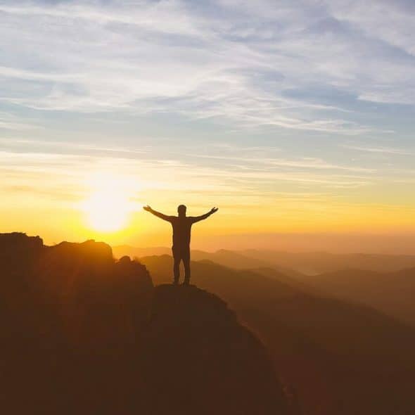 A man with his hands raised to the sky