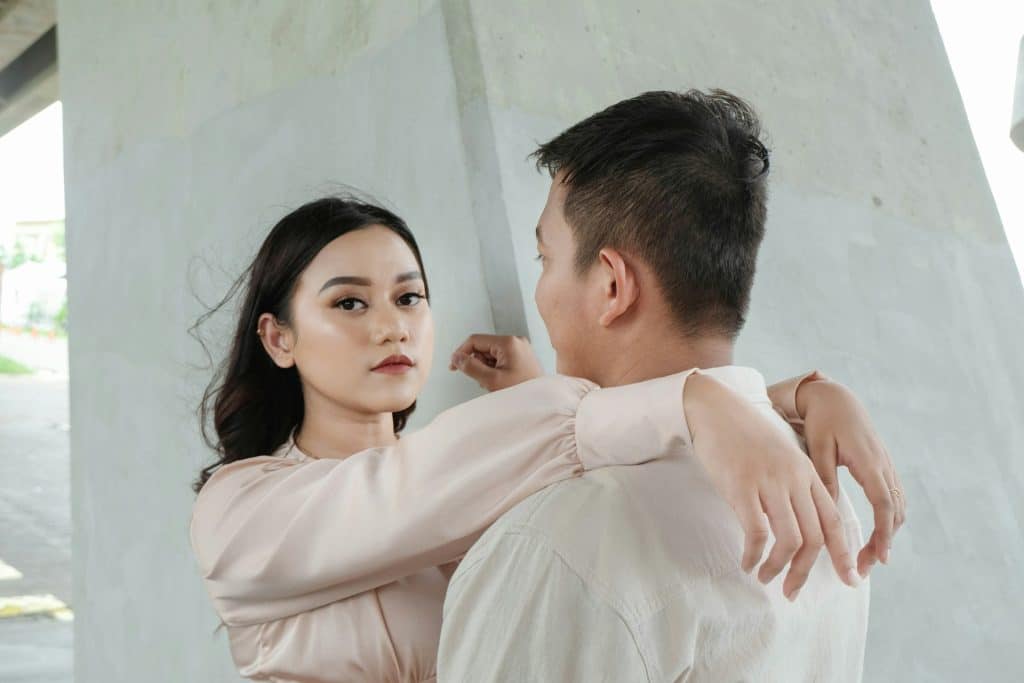 The man is looking at the woman while standing next to her.