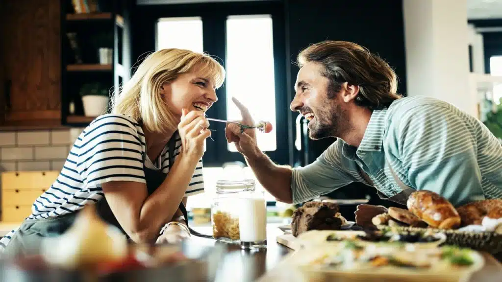 A couple laughing together in the kitchen