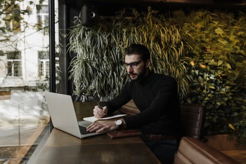 A Man using Laptop while Writing