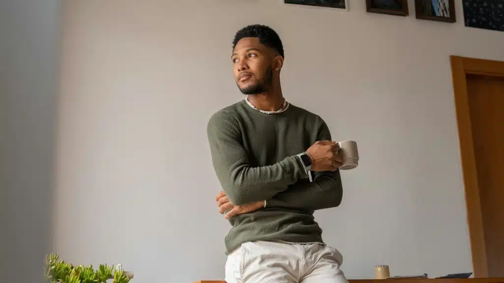 A man holding a coffee cup and looking to the side.