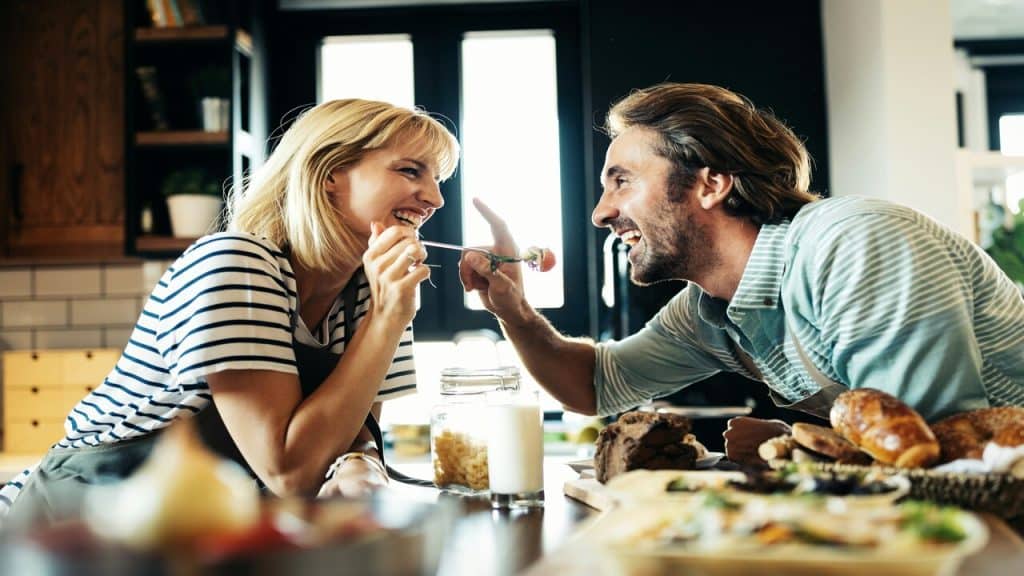 A couple laughing together in the kitchen