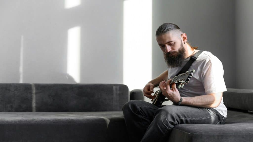 A man playing the guitar at home