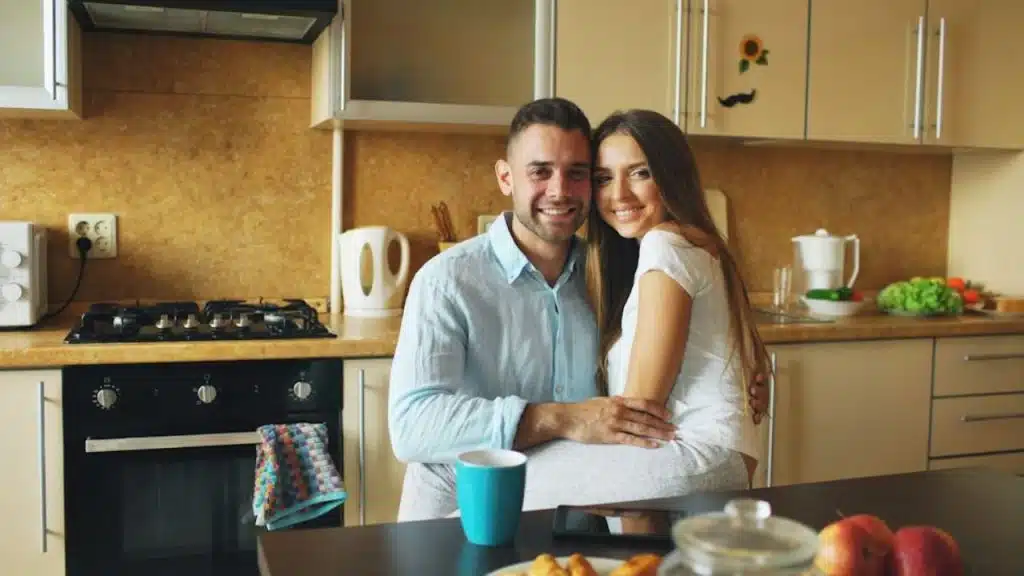 Man embracing his partner affectionately in the kitchen