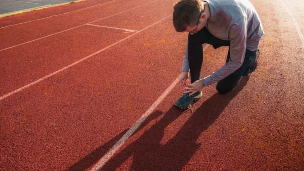 Man tying his running shoes early in the morning