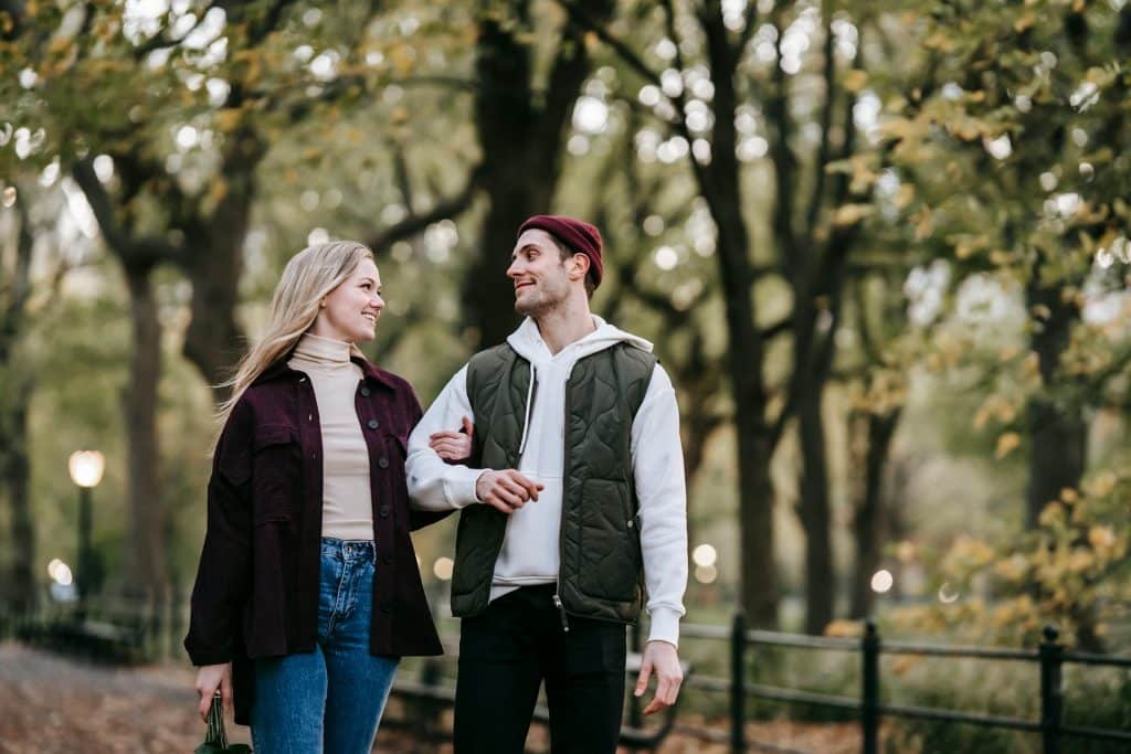 The happy couple is walking in the park.