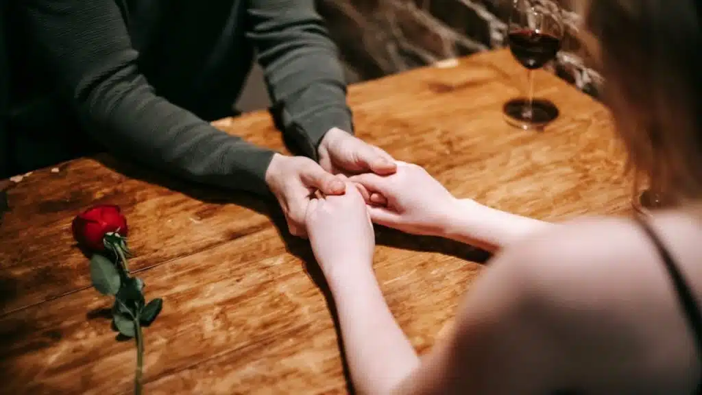 A couple holding hands across the dinner table