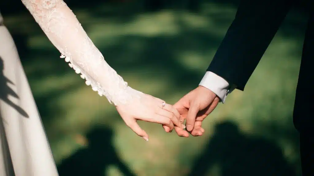 A newly married couple holding hands.
