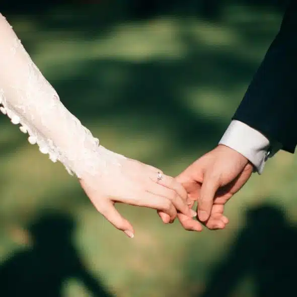A newly married couple holding hands.