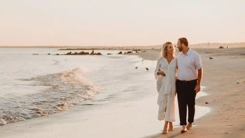 Couple walking arm in arm at sunset