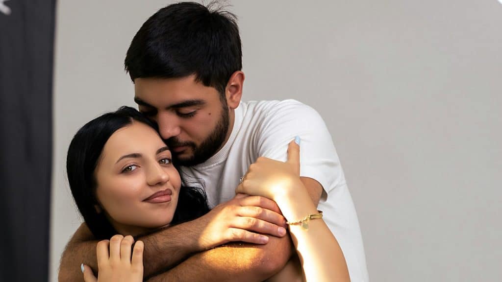 A man hugging a woman from behind.