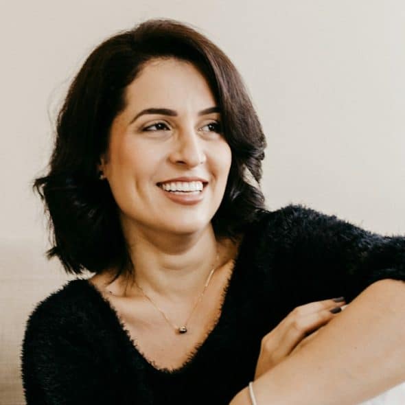 An attractive older woman wearing a black sweater and looking to the side.