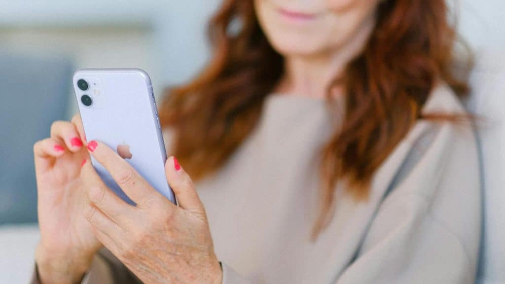 A woman using a smartphone while sitting indoors.