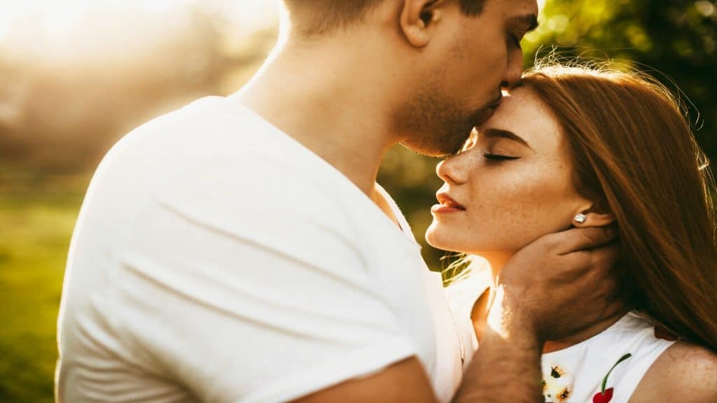 A couple giving his wife a forehead kiss