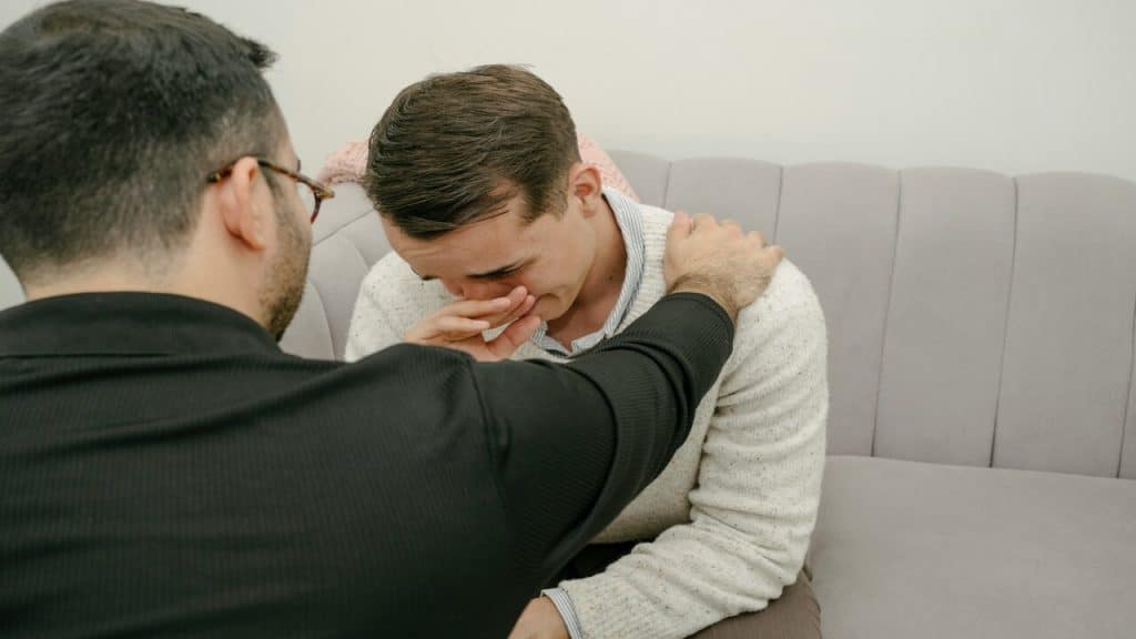 A man comforting his crying friend 