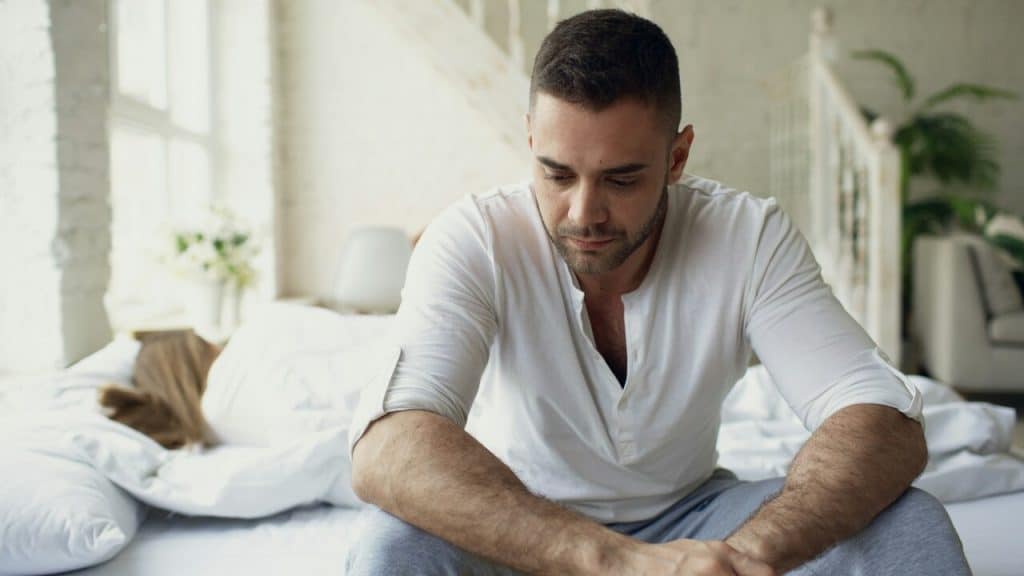 A man looking sad in the bedroom