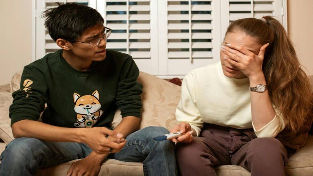 A couple looking frustrated at a pregnancy test
