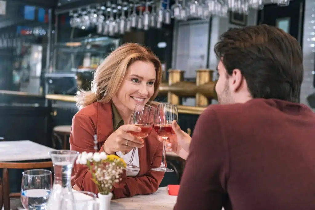 The couple is clinking their wine glasses together.