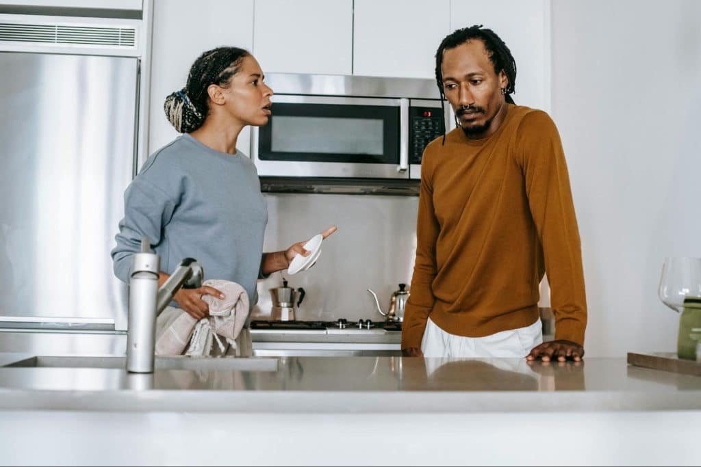 A man looking guilty and avoiding a woman’s question