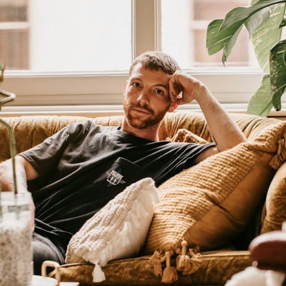 A man relaxing on a couch in his home.
