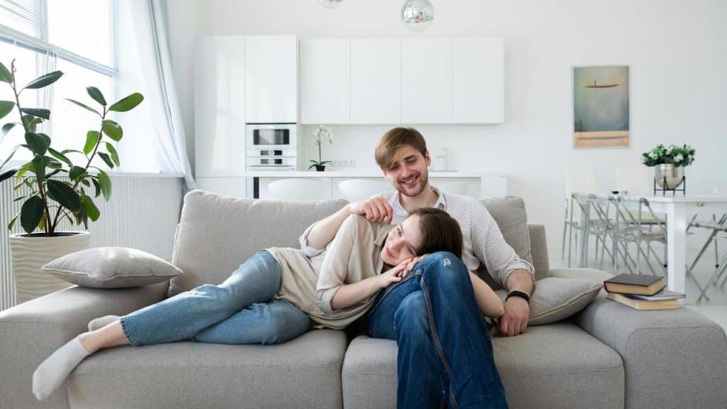 A couple relaxing on a couch in a bright, modern living room.