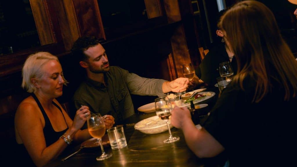 A group of people dining together at a dimly lit restaurant.