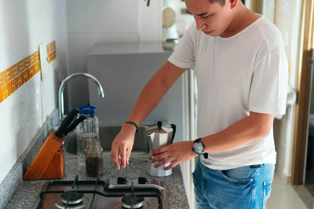 The man is preparing coffee at home.