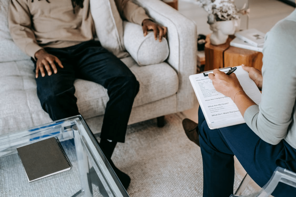 Crop unrecognizable black man sharing complains with female psychologist