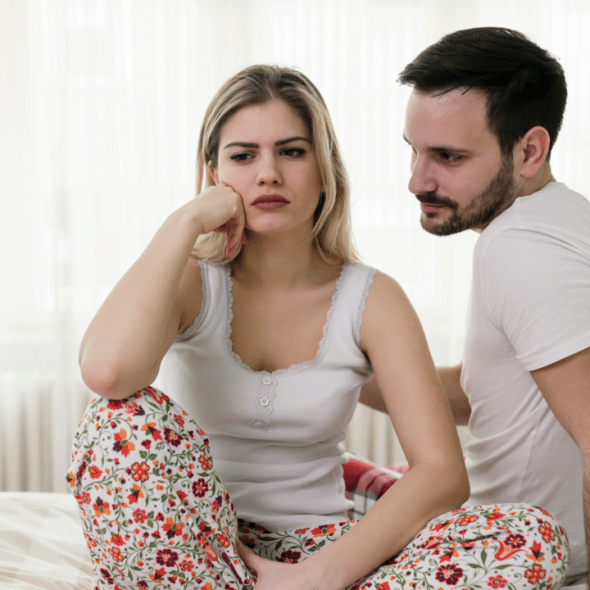 A couple looking sad in the bedroom