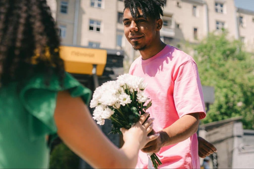 A man giving a woman a flower 