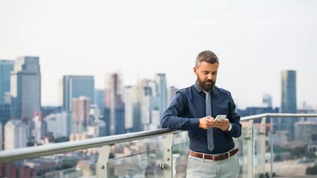 A man looking at his phone, deciding whether to reply.