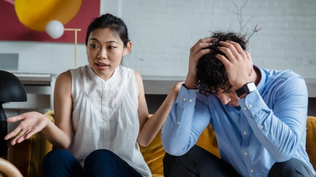 Man sitting in silence while his partner talks emotionally