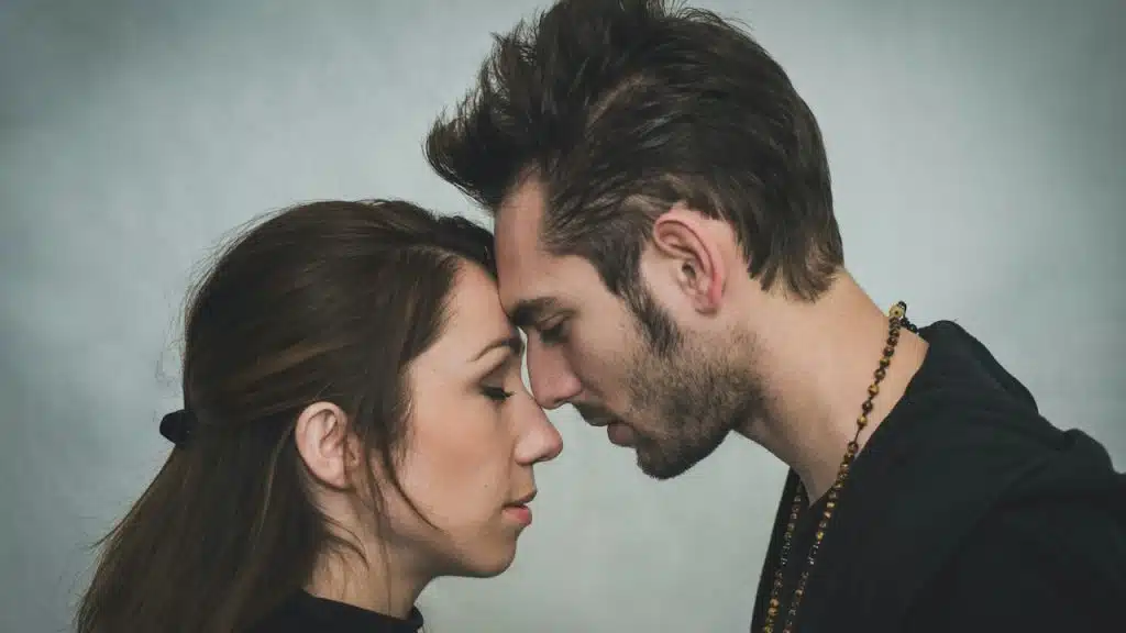 A man and woman touching their foreheads.