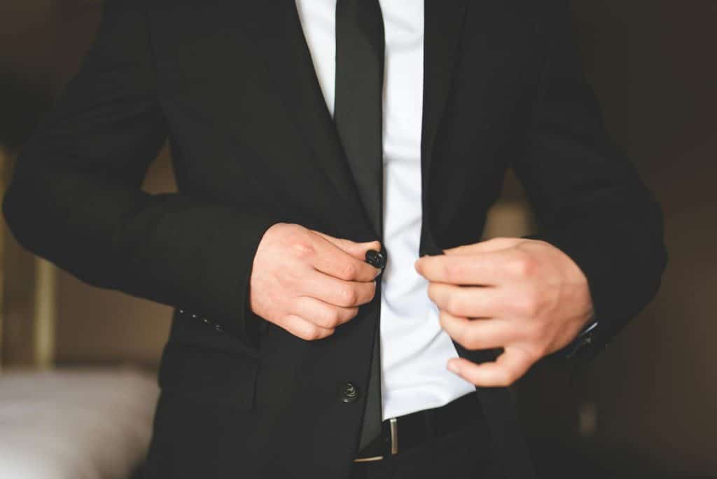 The man is wearing a black suit.