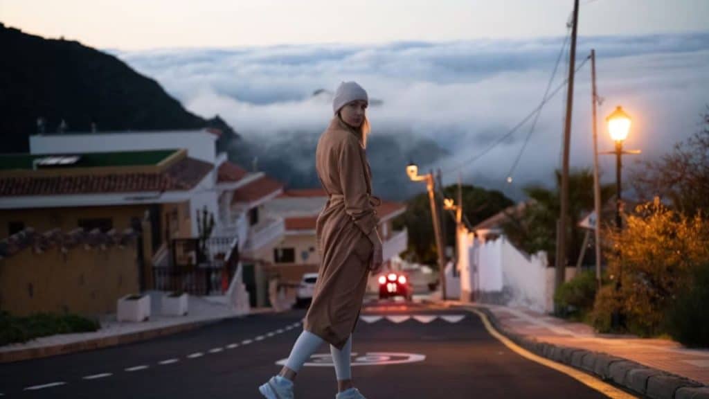 Woman walking away from home at sunrise
