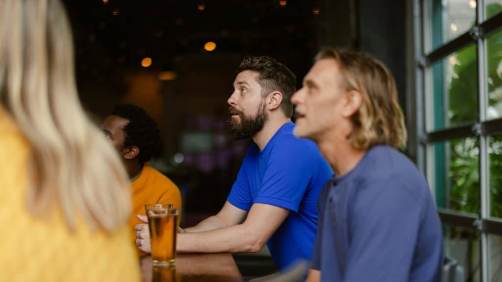A couple of men seated at a table and looking at something.
