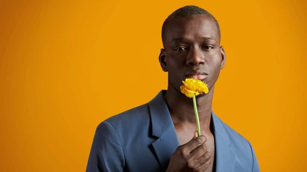 A man holding a yellow flower.