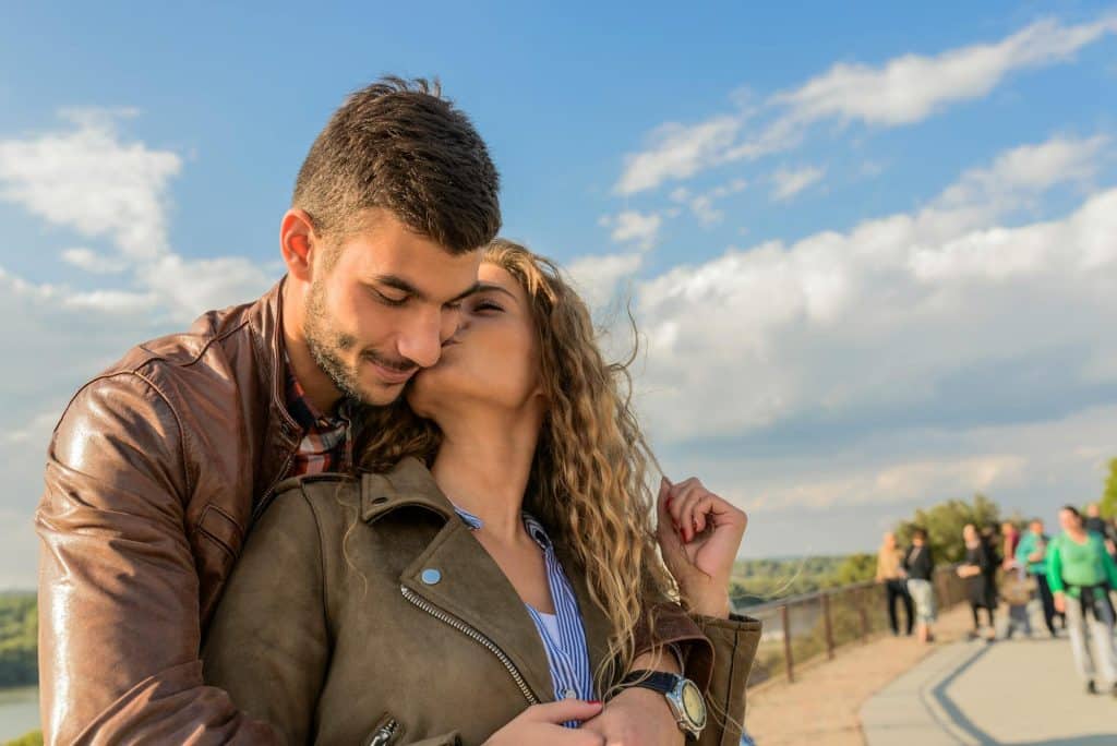 The woman is kissing the man.
