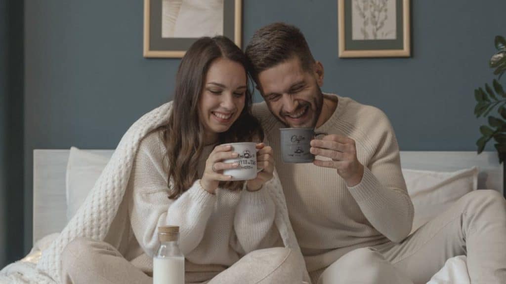 A couple smiling at each other over morning coffee